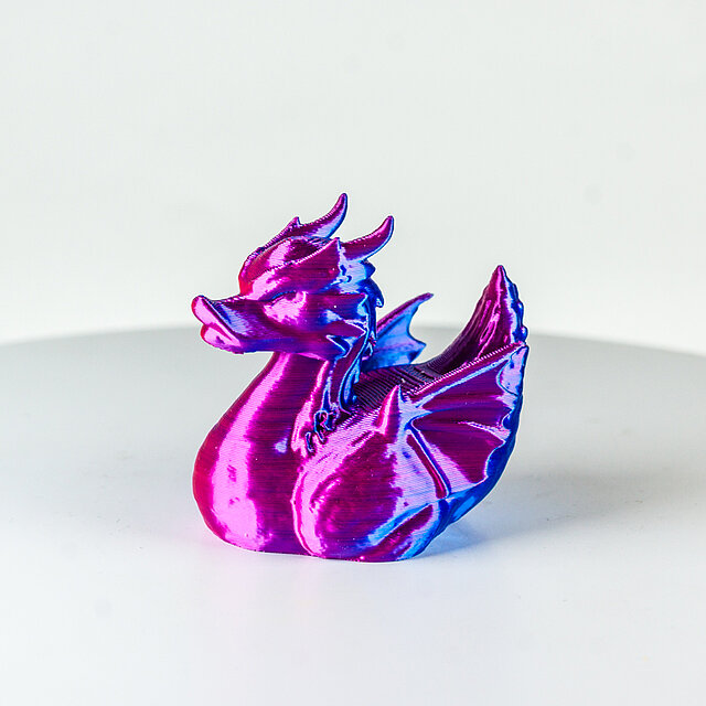 Drache aus einem 3D Drucker, blau rot schimmernd